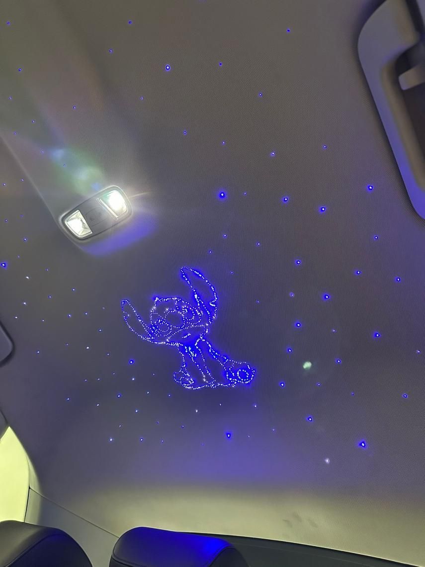 Techo de automóvil con luces de estrellas azules y un personaje de Stitch con contorno azul.