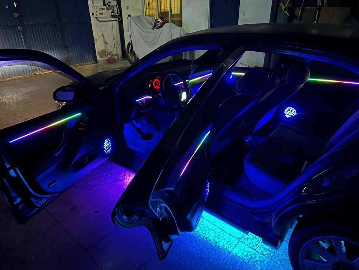 Interior del coche con luces LED de colores que iluminan los marcos de las puertas y el pis, configuración nocturna.