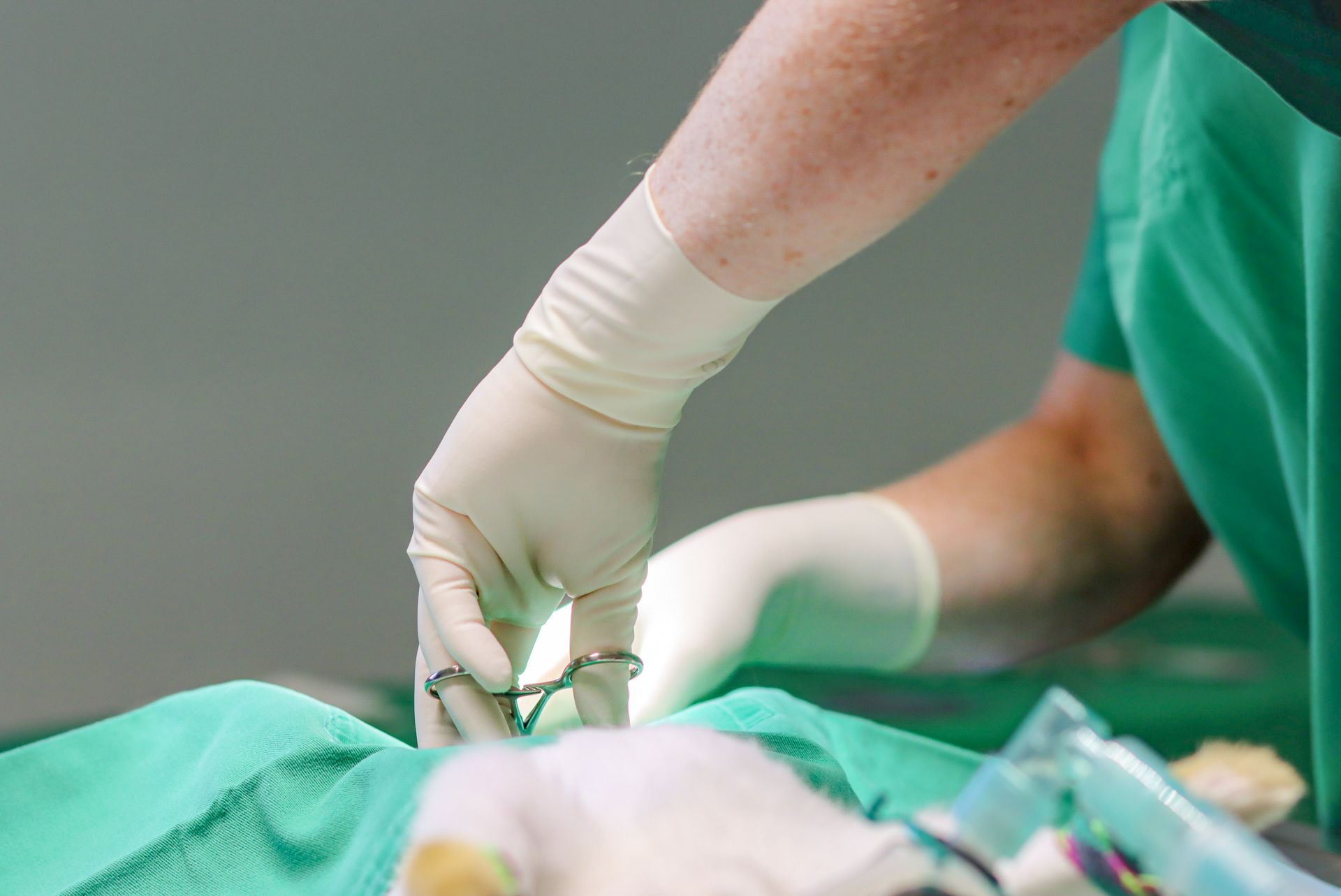 Un chirurgien tient une paire de ciseaux pendant qu'il opère un patient.