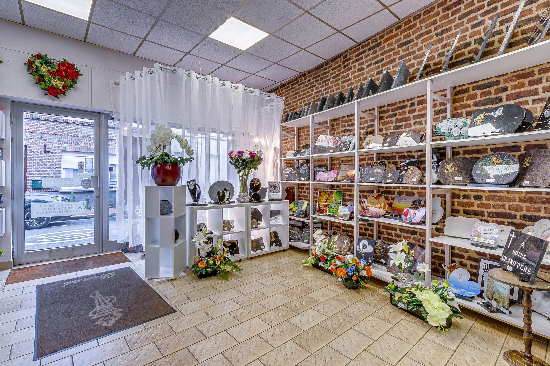 Intérieur d'un salon funéraire avec des étagères de fleurs et de plaques funéraires