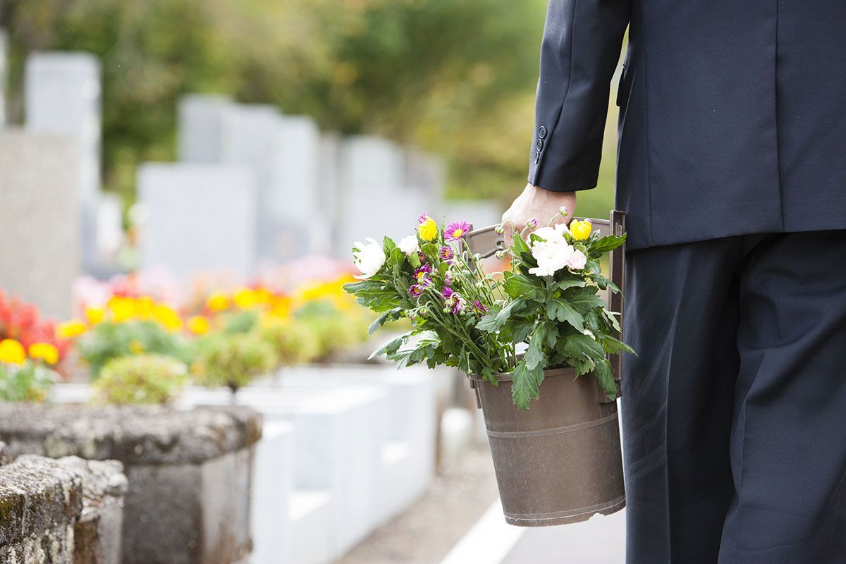 Homme qui amène des fleurs sur une tombe