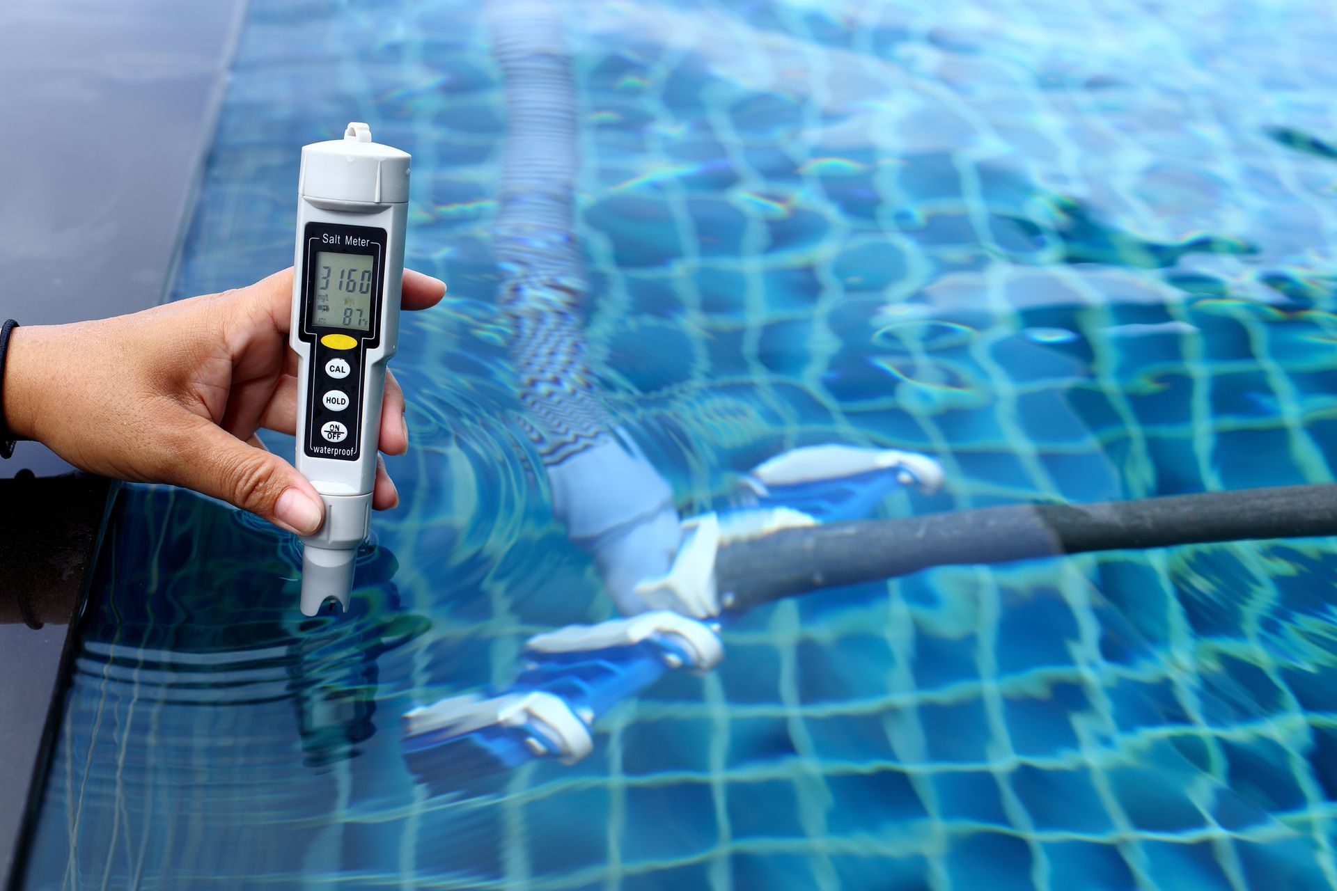Une personne mesurant la température d'une eau de piscine.