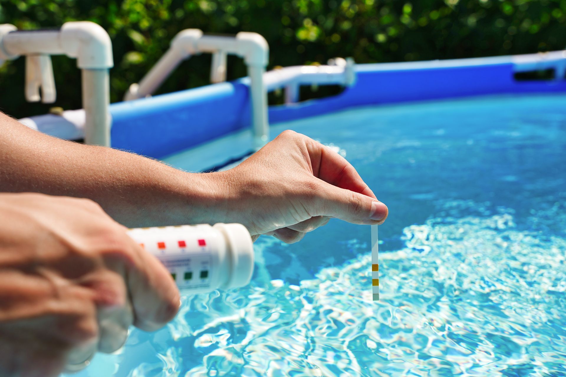 Une personne mesurant le pH d'une piscine.
