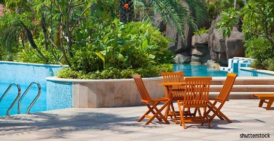 Une table et des chaises au bord d'une piscine.