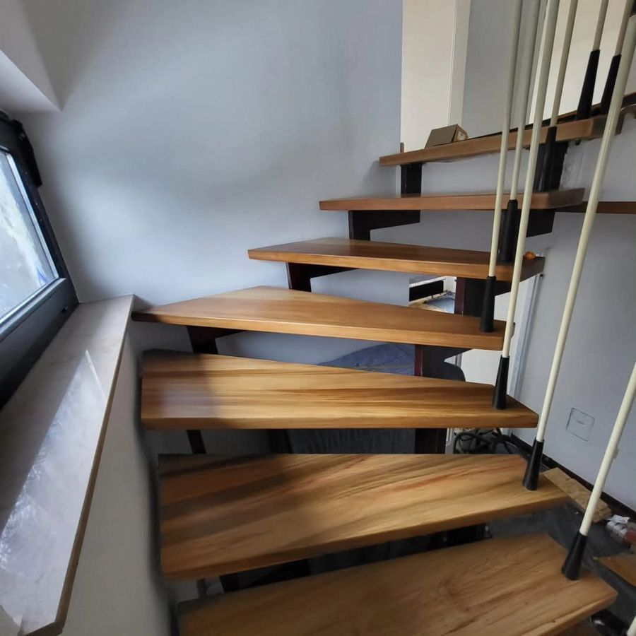 Eine Holztreppe in einem Raum mit einem Fenster