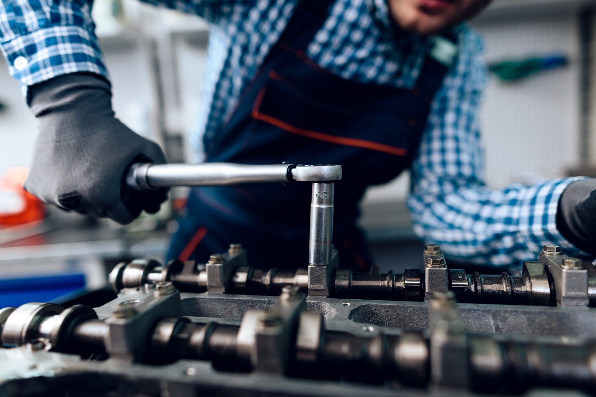 Un hombre está trabajando en una máquina con una llave inglesa.