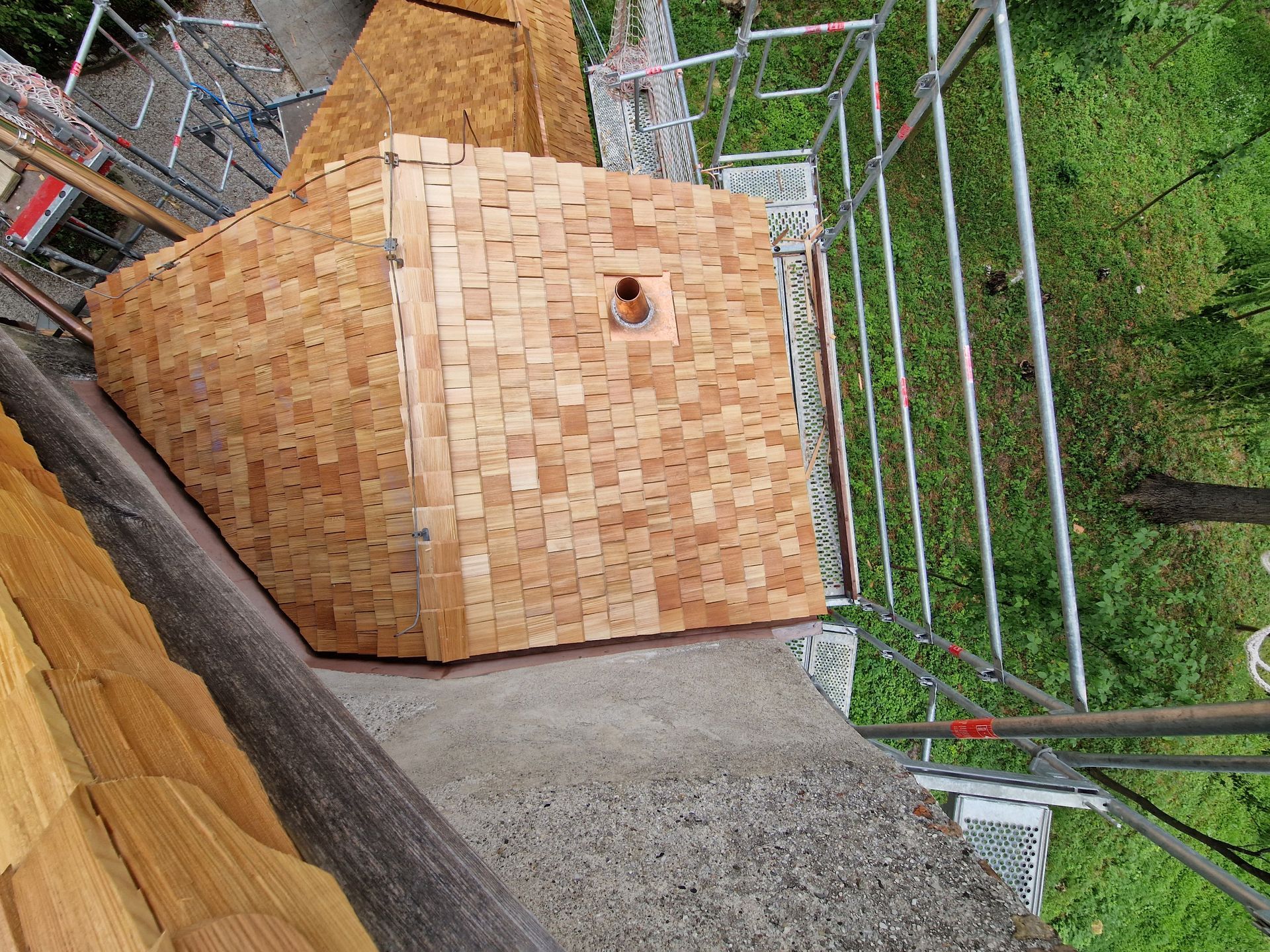 Holzkubus mit neuem Schindeldach in Sanierung