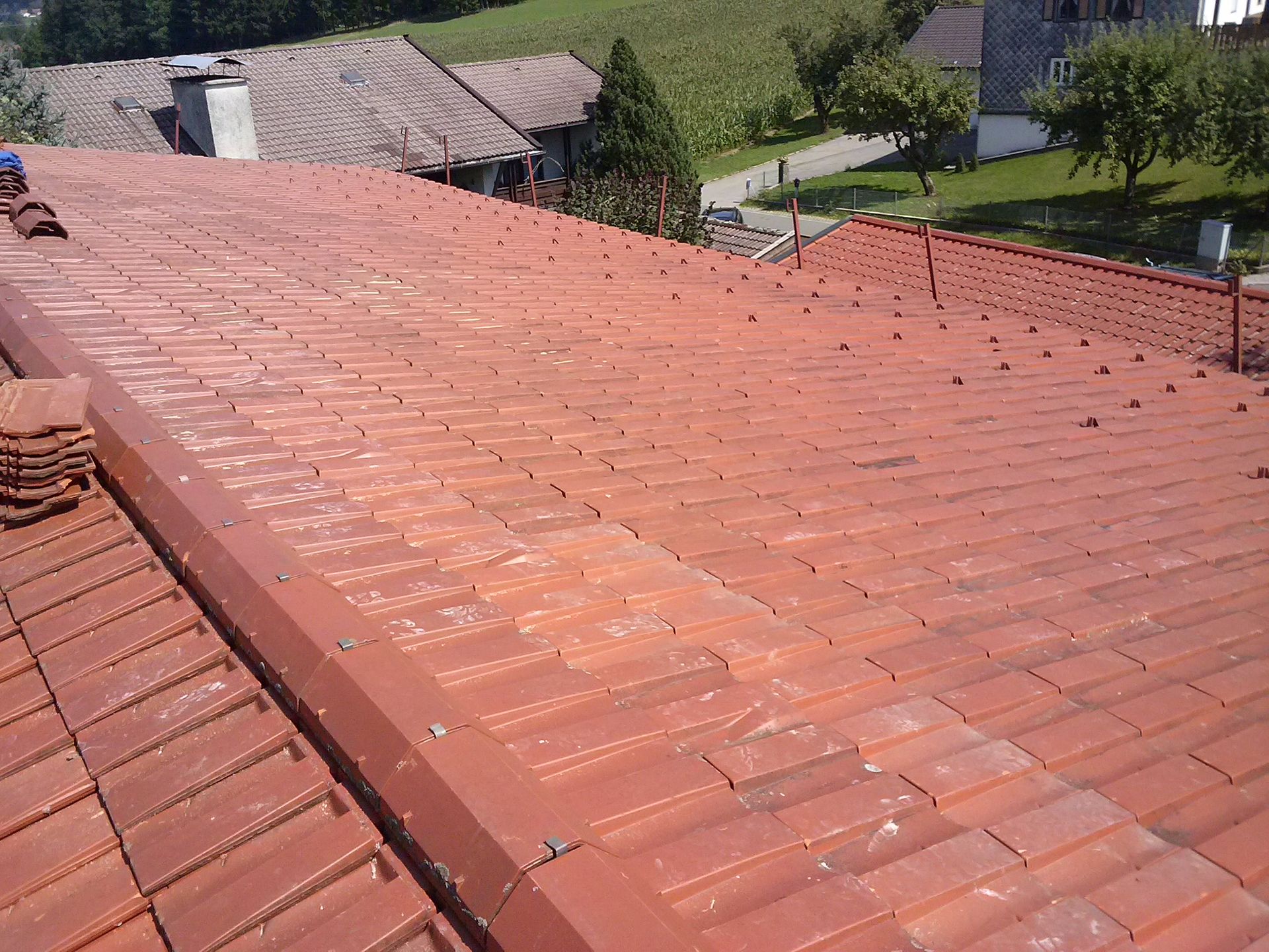 Neue Ziegel in Rotton auf saniertem Dach