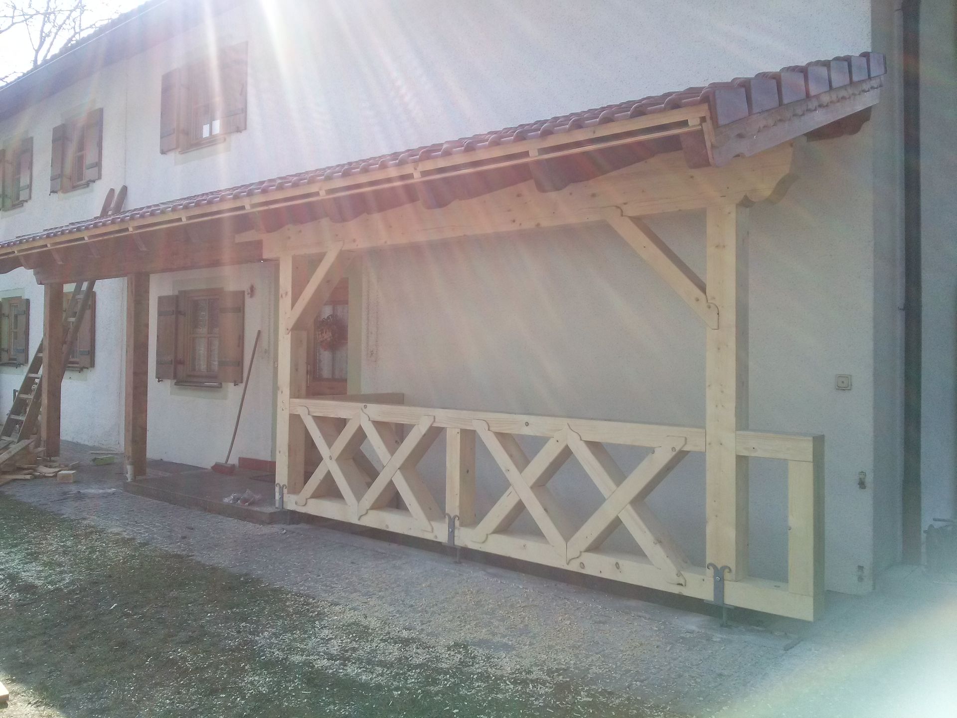 Überdachte Terrasse mit Holzbalken vor Wohnhaus