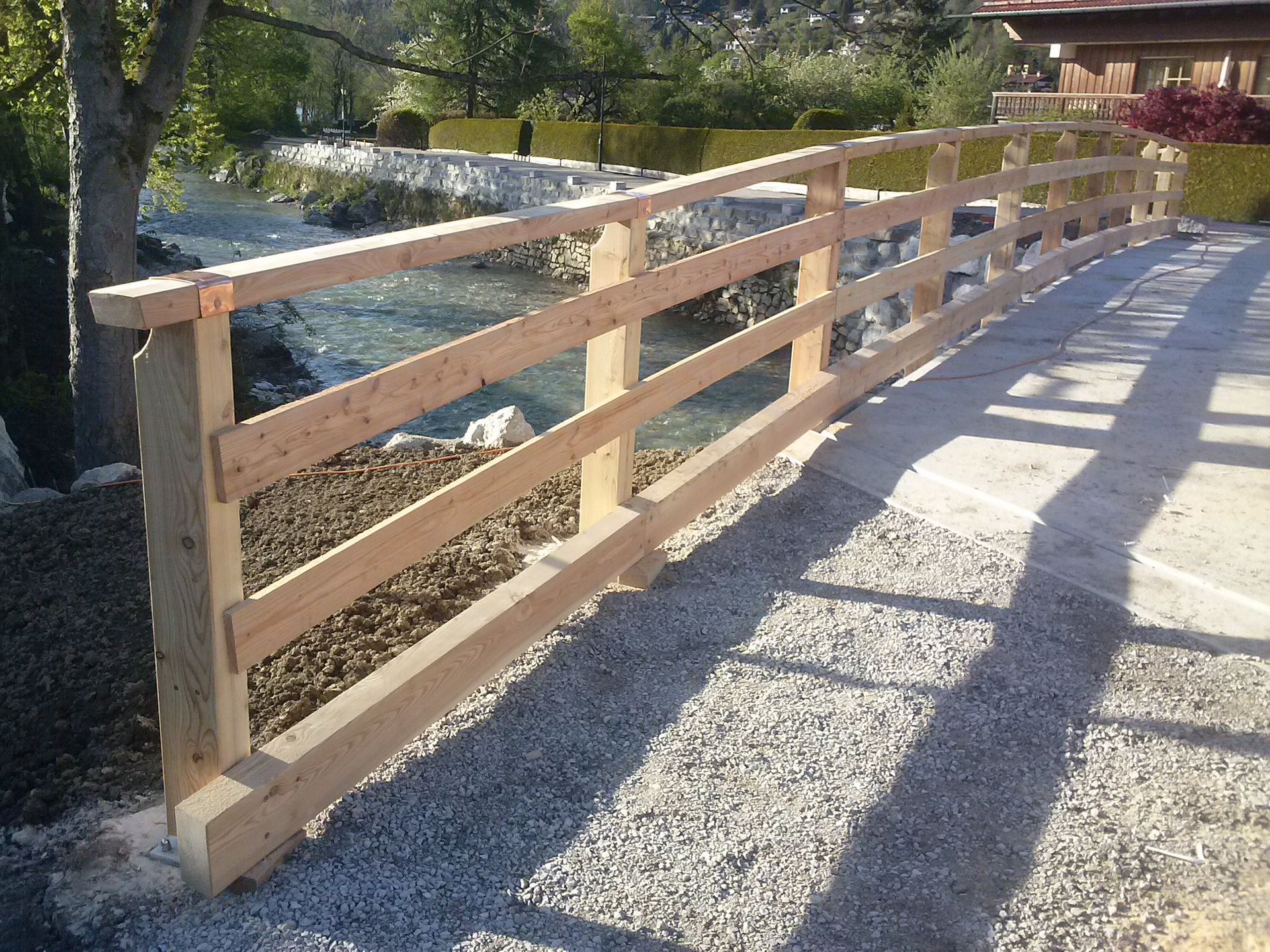 Holzgeländer entlang Kiesweg im Außenbereich