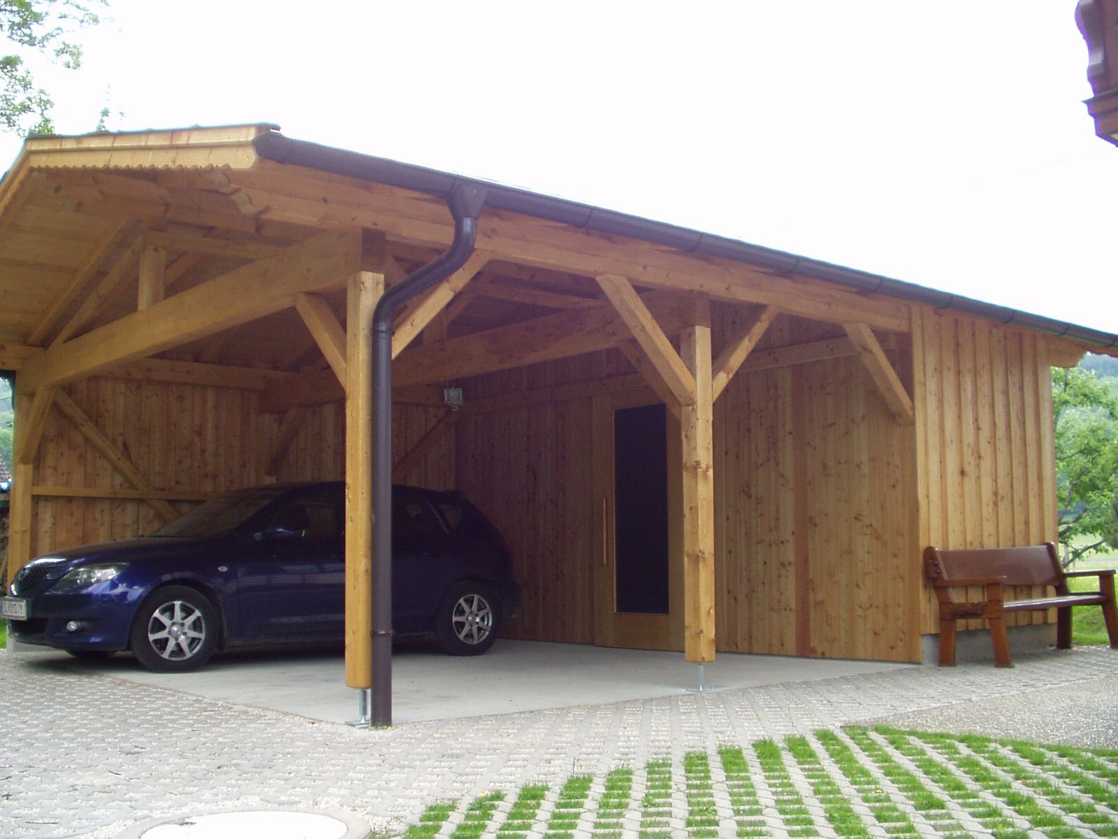 Doppelcarport aus massivem Holz mit Seitenwänden und Auto