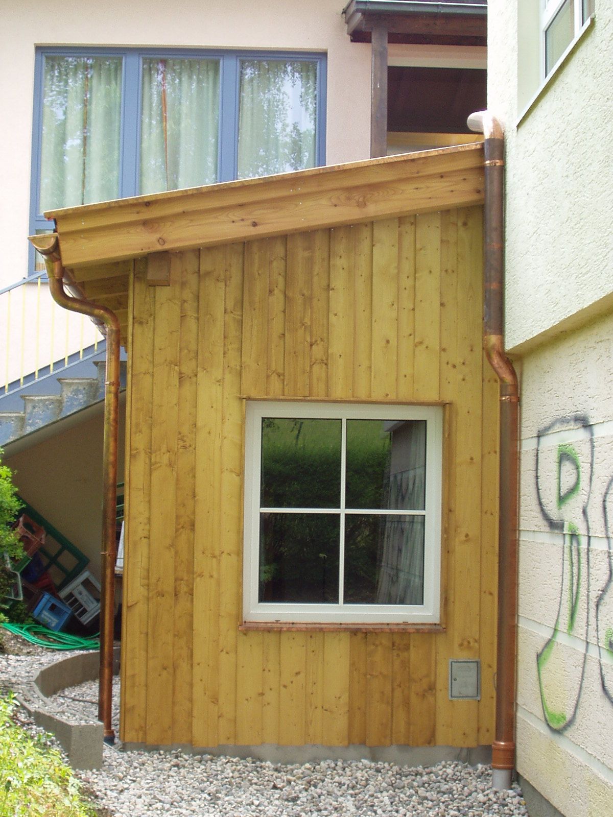 Seitenansicht eines Hauses mit Holzfassade und Fenster