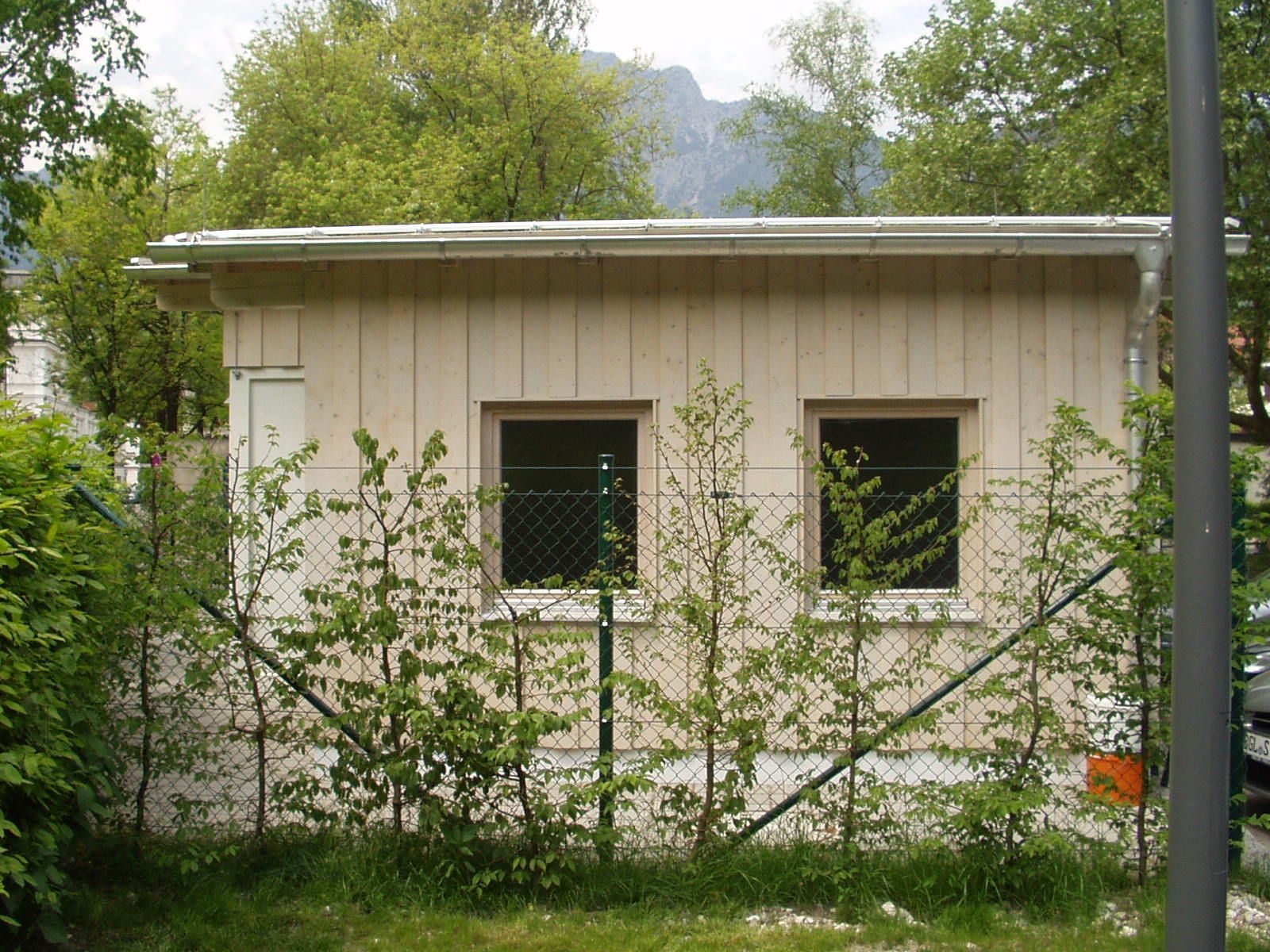 Gartenhaus mit hellem Holz und begrüntem Außenbereich