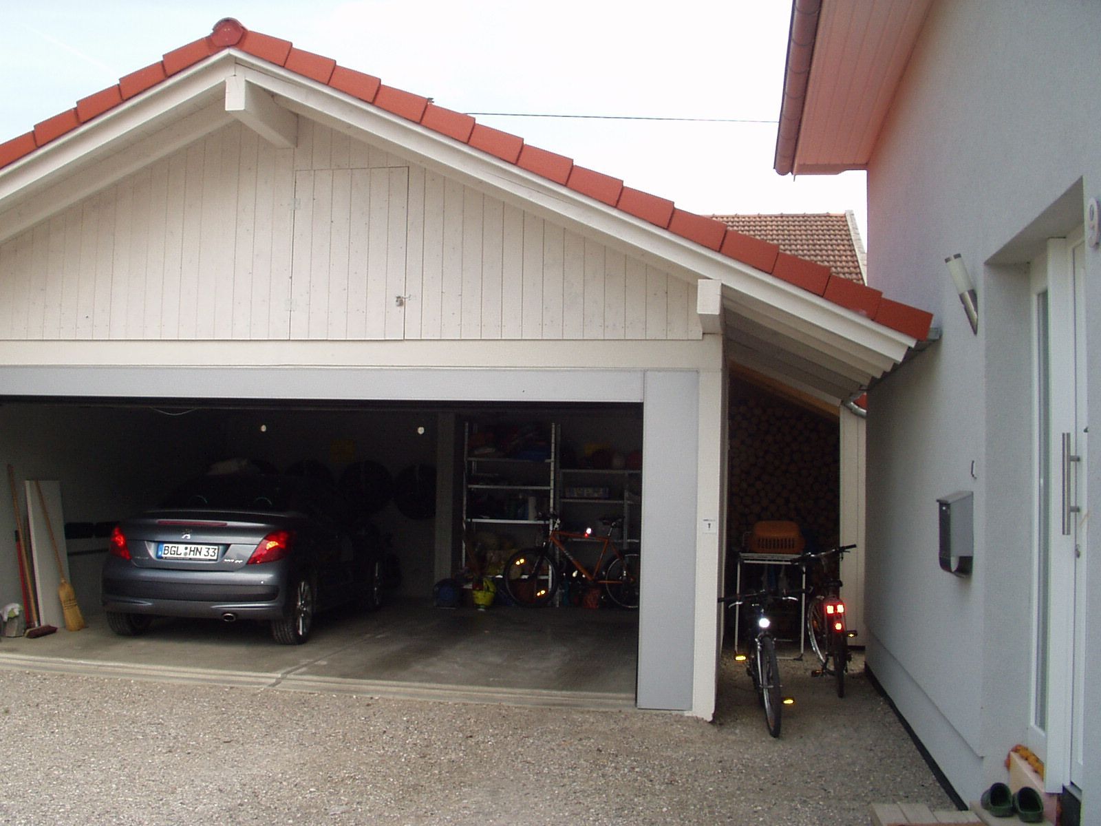 Offener Carport mit hellem Holz und geparktem Fahrzeug