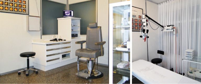 Sala de tratamiento dental con equipamiento blanco, taburetes, armarios y un sillón de exploración junto a una ventana.