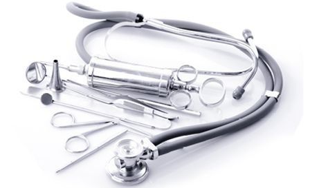 Estetoscopio y otros instrumentos médicos de plata sobre un fondo blanco.