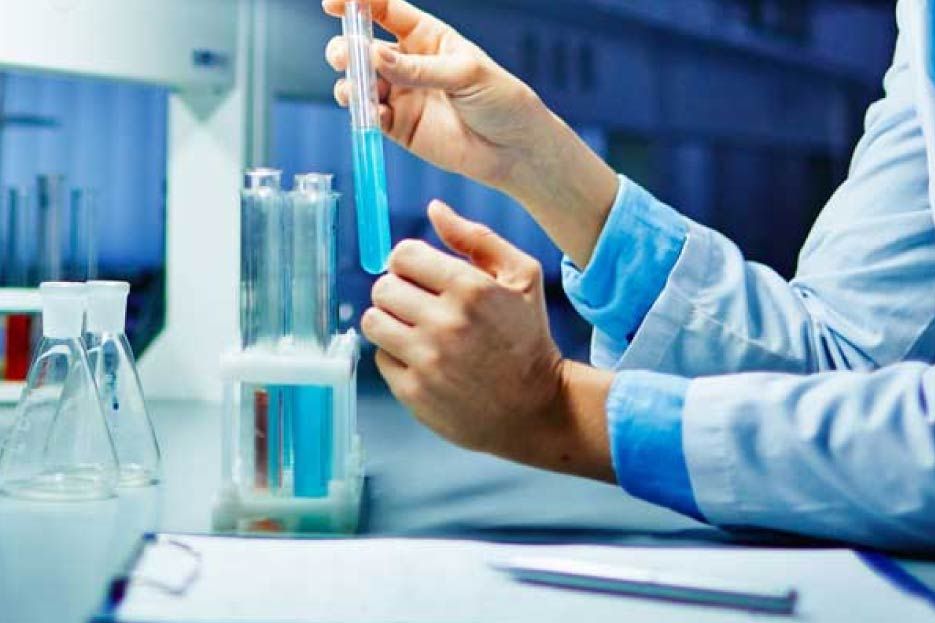 Un científico sostiene un tubo de ensayo con un líquido azul dentro.