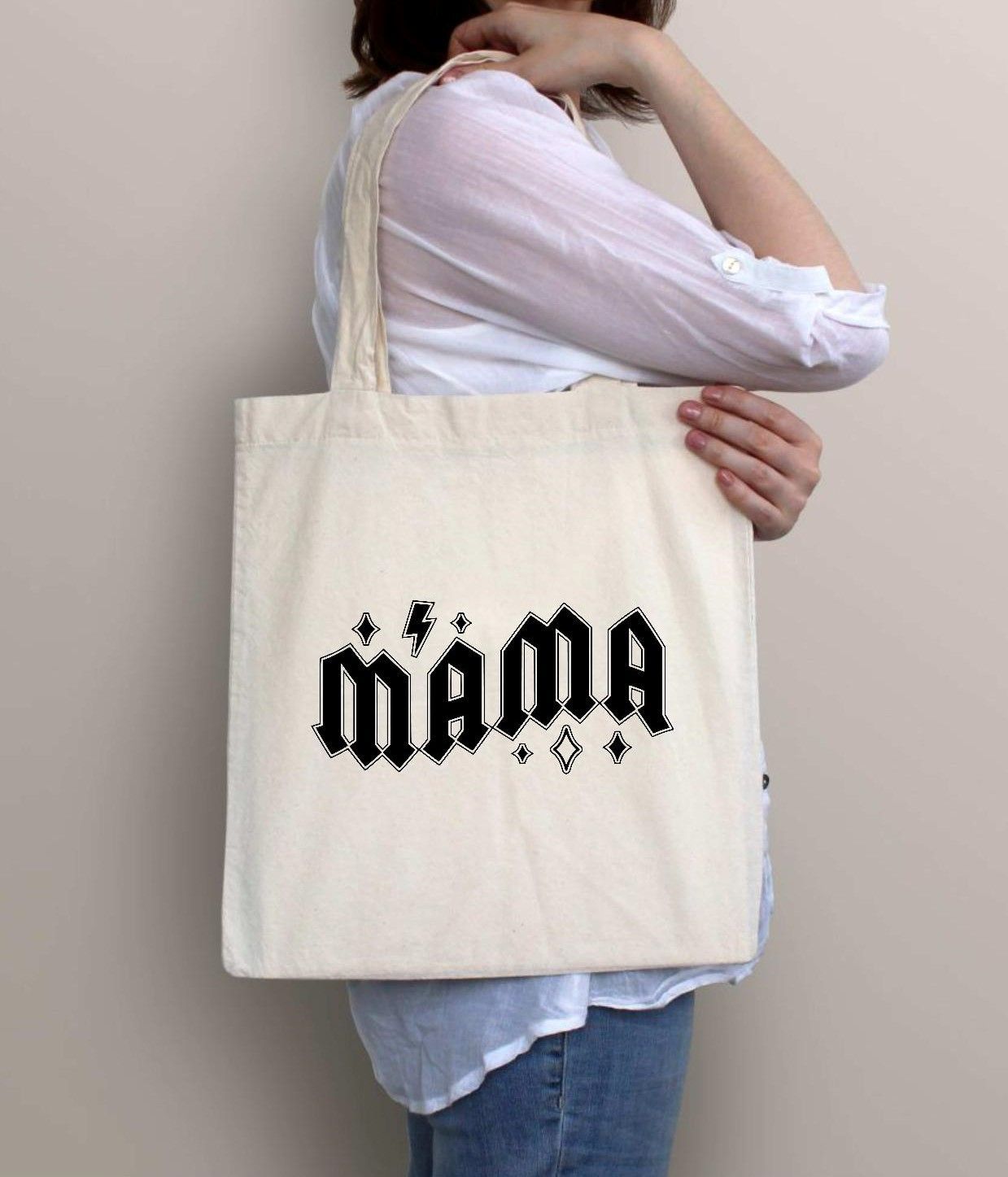 Mujer sosteniendo una bolsa de mano de color crema con la palabra 