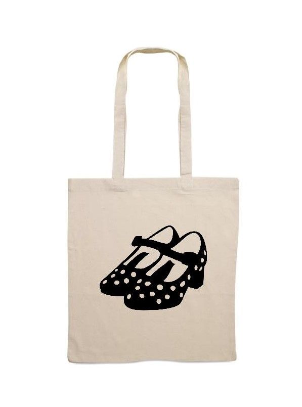 Bolso de mano con zapatos Mary Jane negros con lunares blancos.