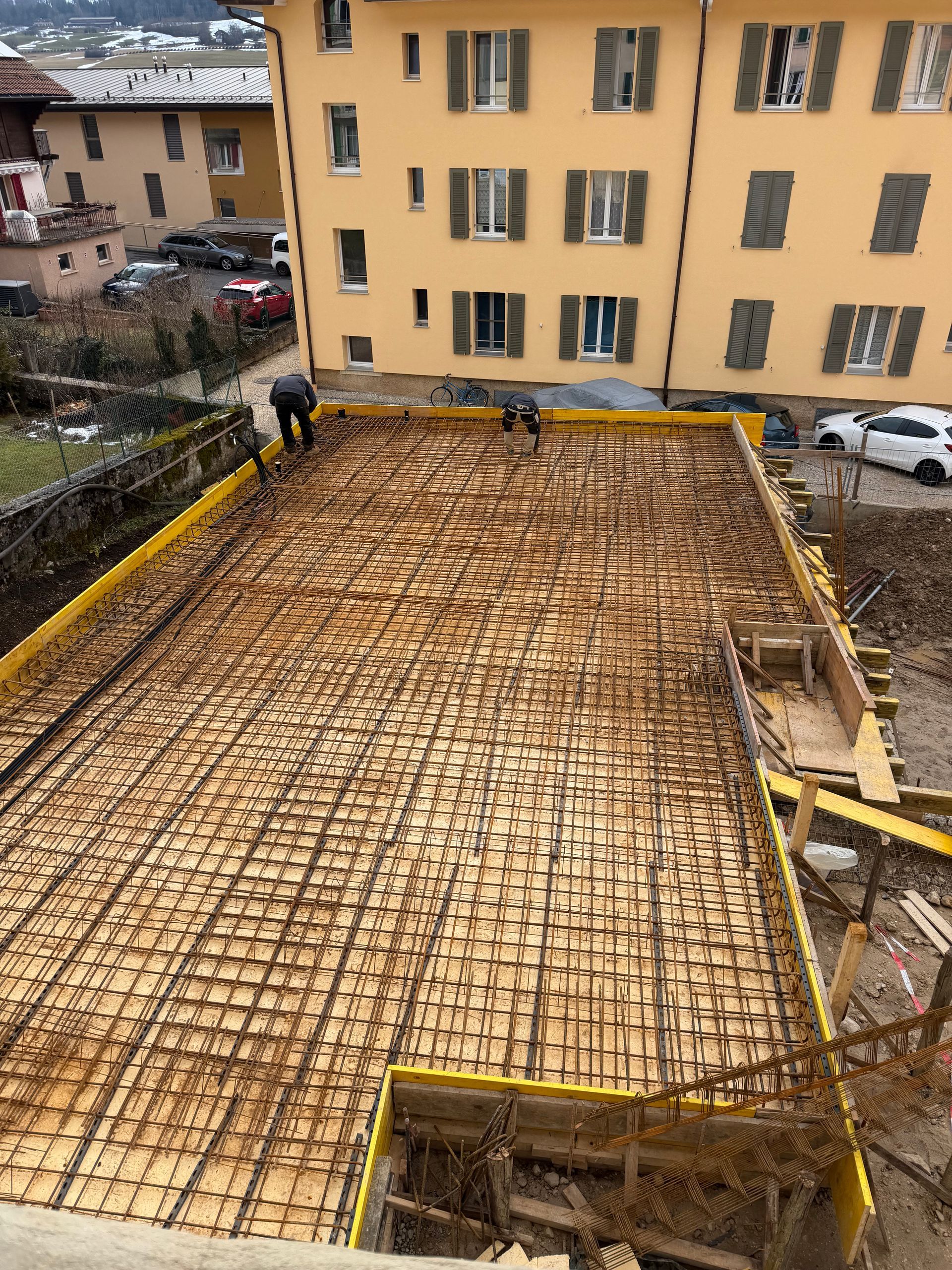 Un ouvrier du bâtiment utilise une truelle pour appliquer du mortier et poser une brique.