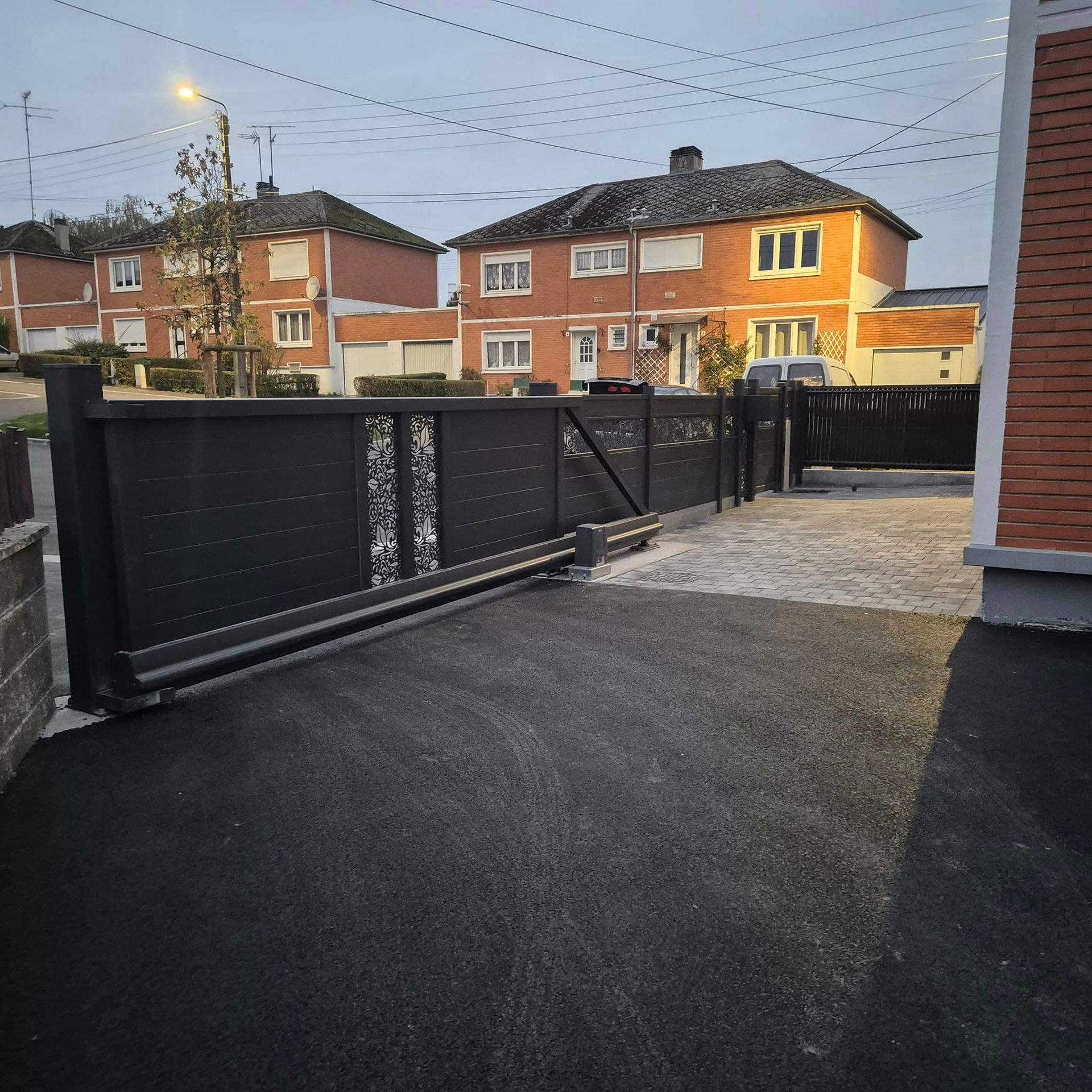 Une allée goudronnée avec décor en pavés