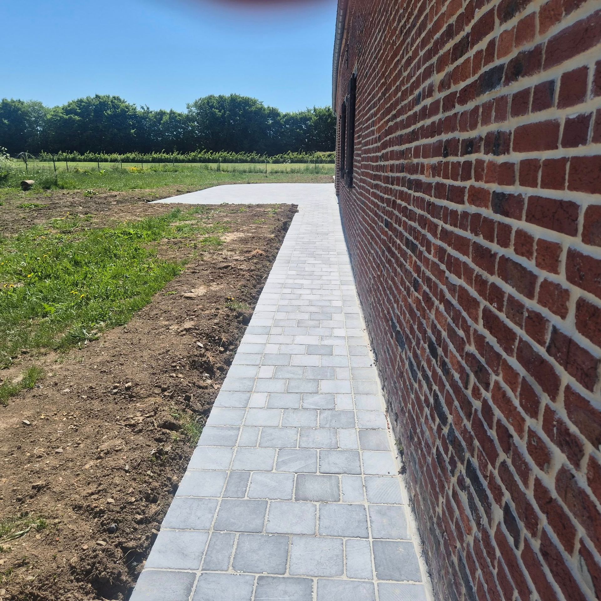 Une allée pavée le long d'un mur