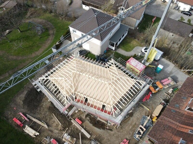 Eine Luftaufnahme eines im Bau befindlichen Gebäudes mit einem Kran im Hintergrund. Foto von der AK Holzwerkstatt GmbH