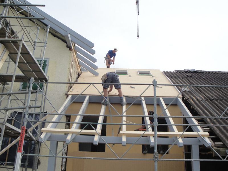 Zwei Männer arbeiten auf einem Dach. Foto von der AK Holzwerkstatt GmbH