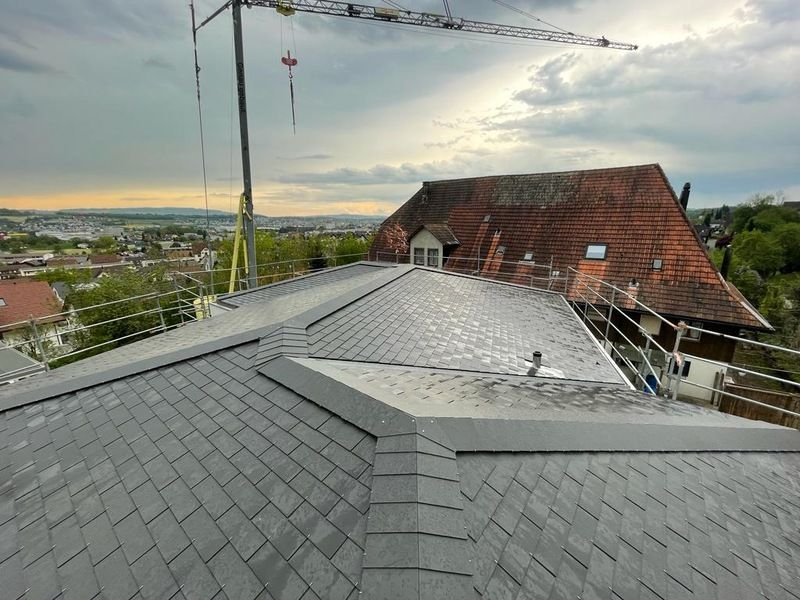 Das Dach eines im Bau befindlichen Gebäudes mit einem Kran im Hintergrund. Foto von der AK Holzwerkstatt GmbH