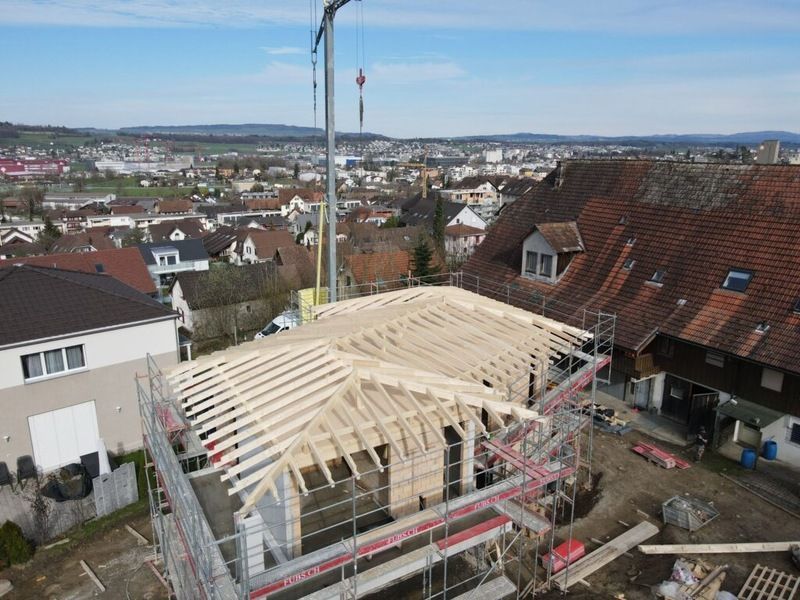 Eine Luftaufnahme eines im Bau befindlichen Gebäudes mit einem Kran im Hintergrund. Foto von der AK Holzwerkstatt GmbH