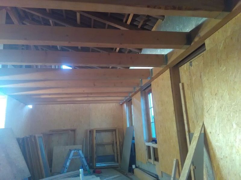 Ein Raum mit Holzbalken und einer Leiter darin. Foto von der AK Holzwerkstatt GmbH