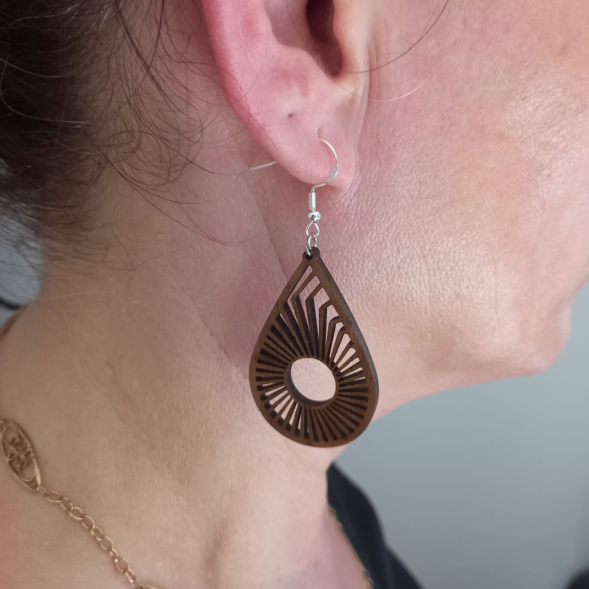 Femme portant une boucle d'oreille en forme de goutte d'eau