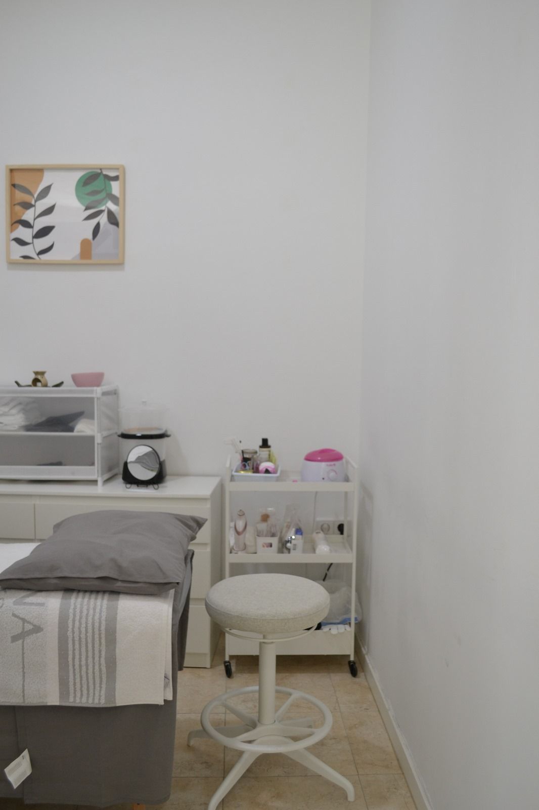 Hay una cama y un taburete en la habitación.