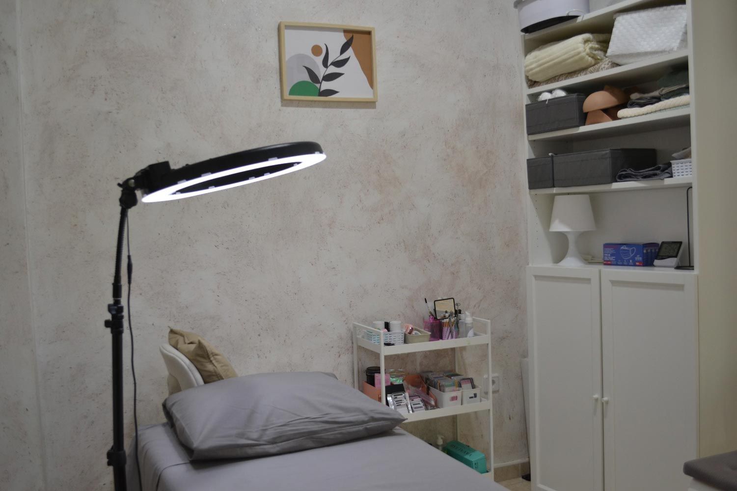 Un dormitorio con una cama, lámpara, estanterías y un cuadro en la pared.