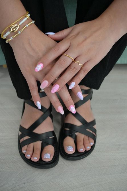 Una mujer lleva un par de sandalias negras y una pulsera.