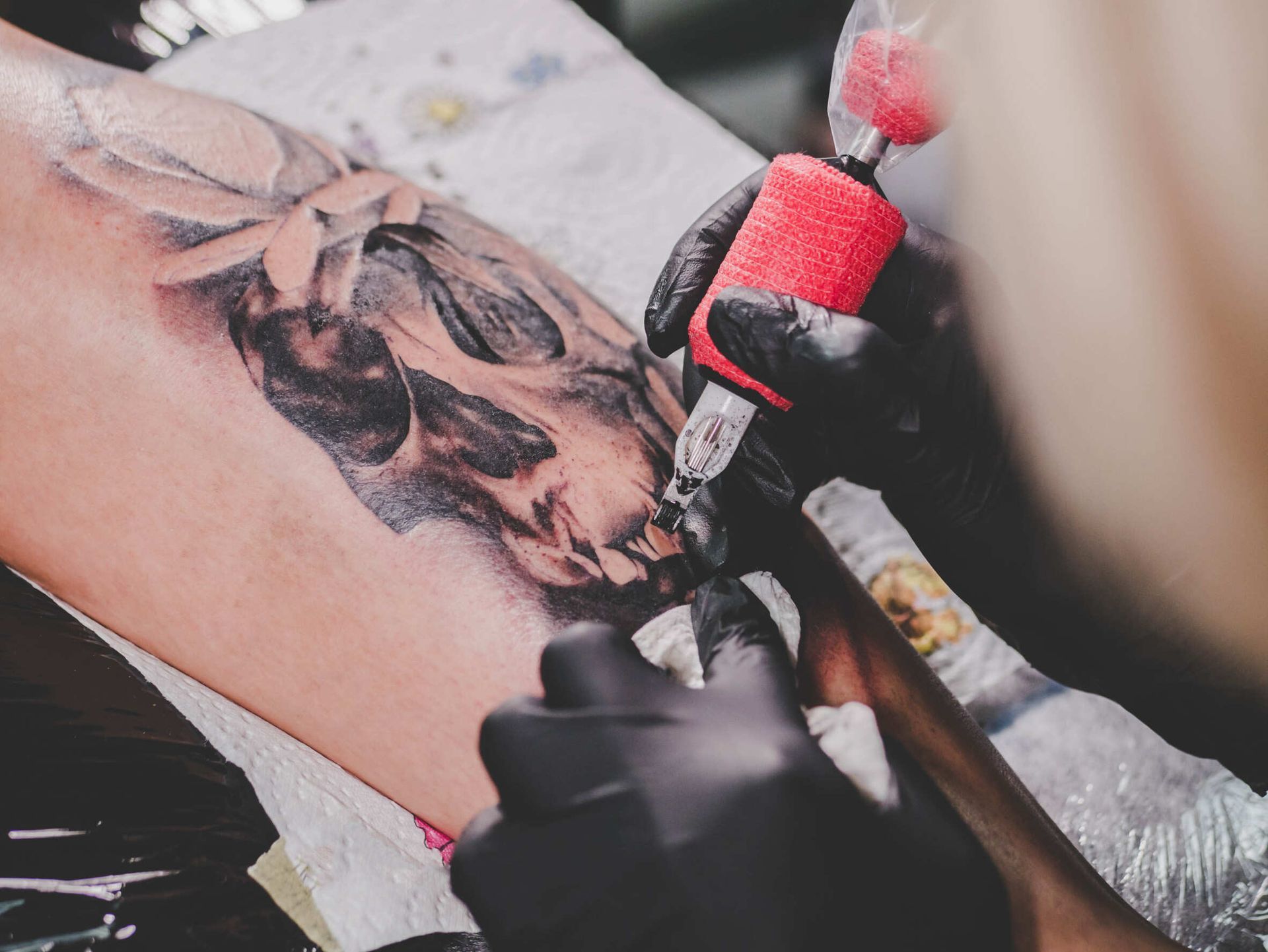 Una persona se hace un tatuaje de una calavera en el brazo.