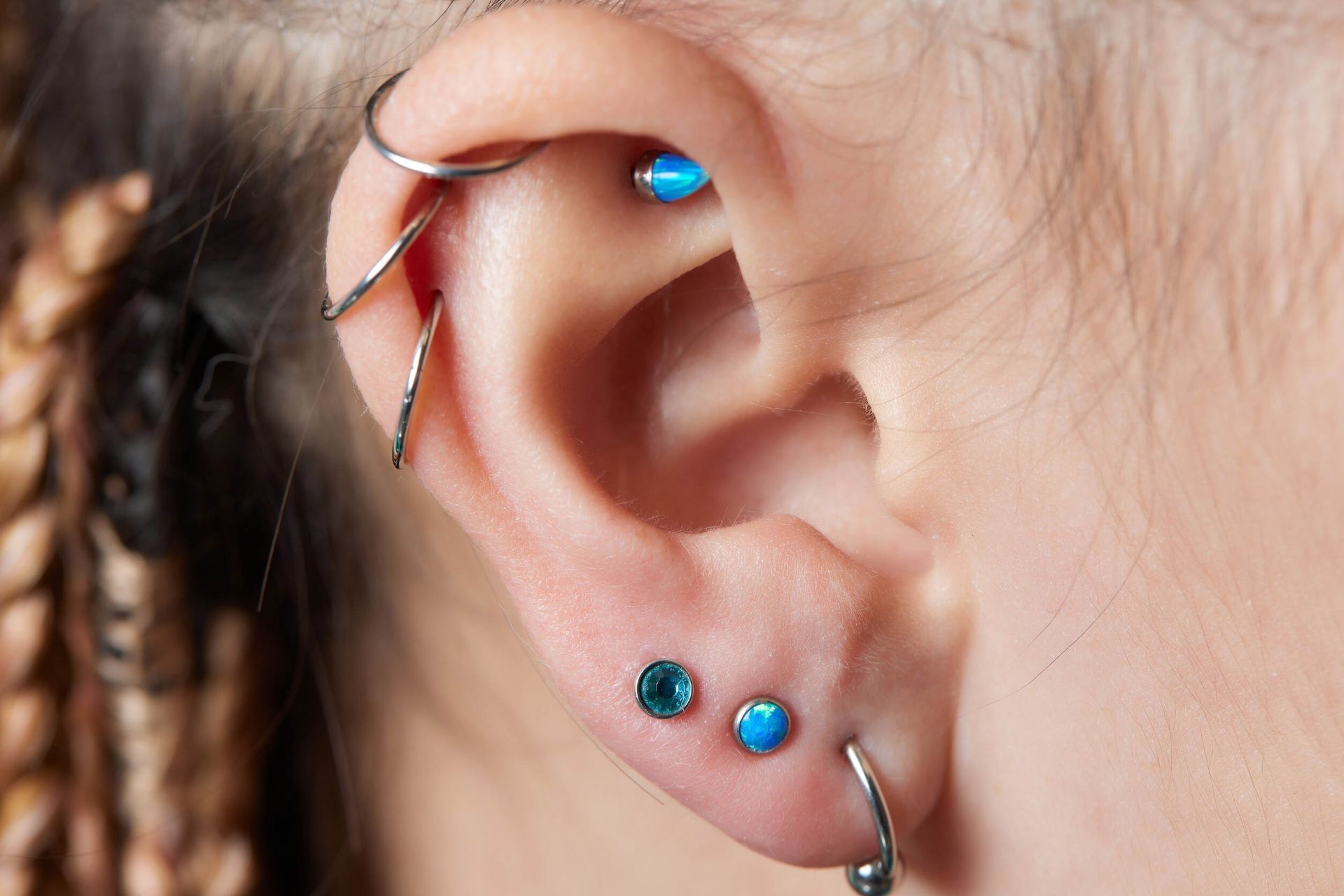 Un primer plano de la oreja de una mujer con múltiples perforaciones.
