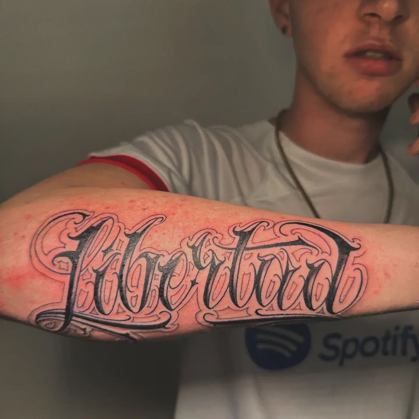 Un hombre tiene un tatuaje de la palabra libertad en su brazo.