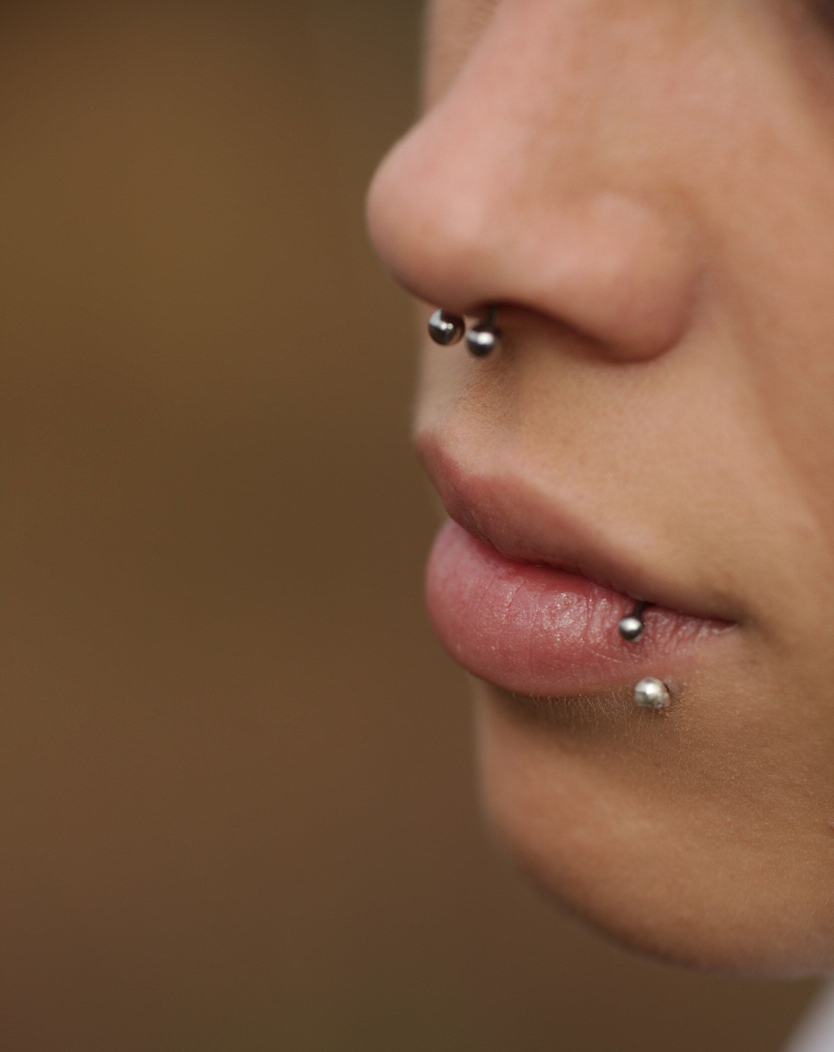 Un primer plano de los piercings en la nariz y el labio de una mujer.