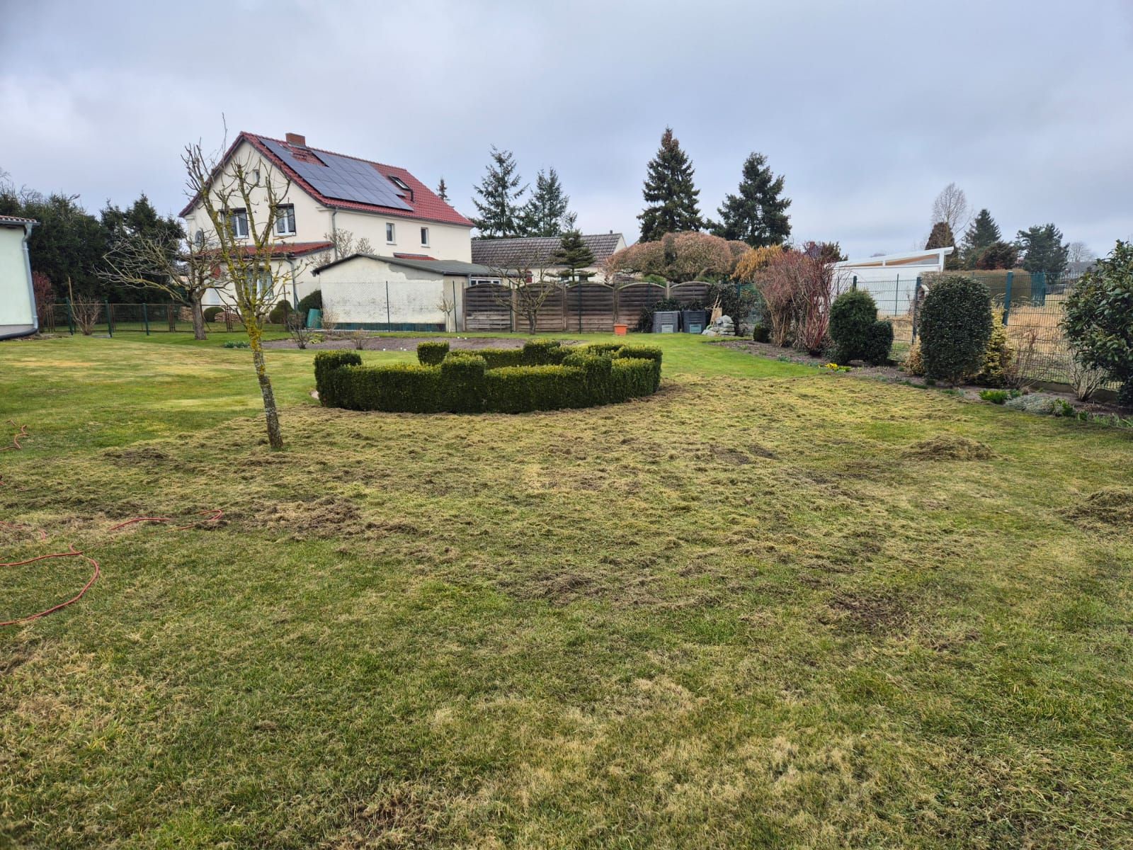 Eine große Wiese mit einem Haus im Hintergrund.