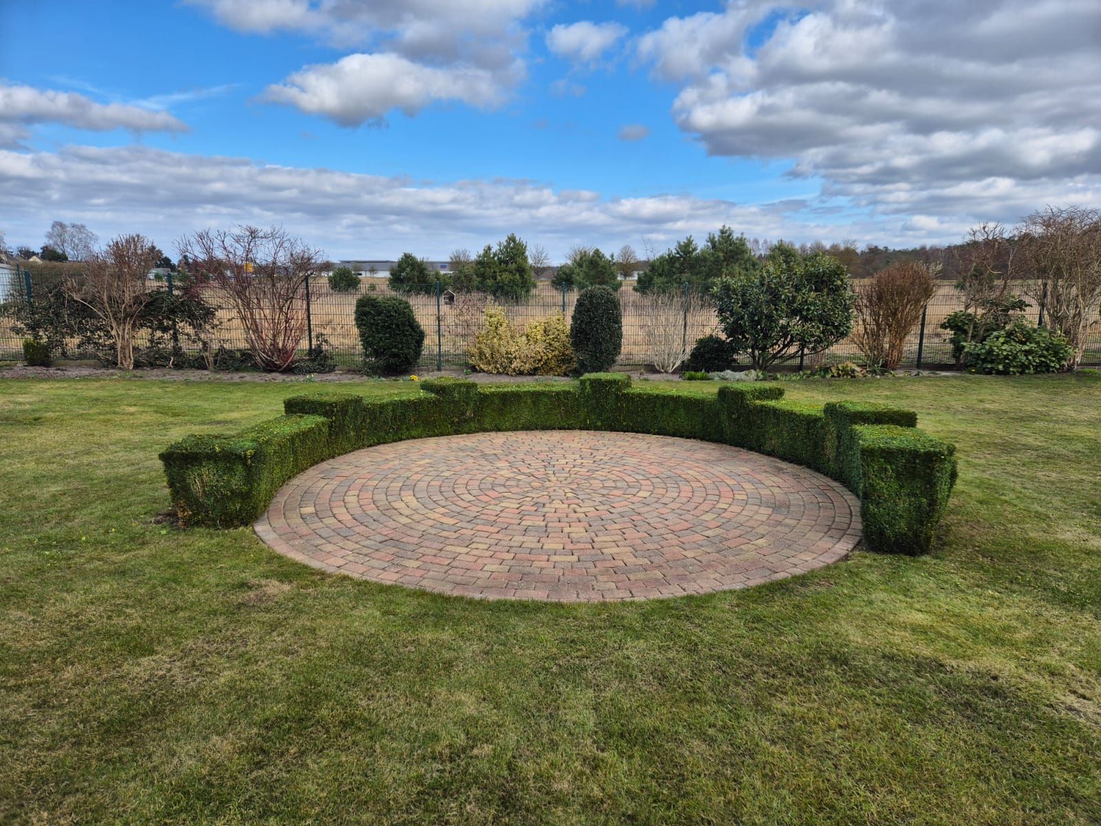 Inmitten einer üppigen grünen Wiese befindet sich ein kreisförmiger Bereich.