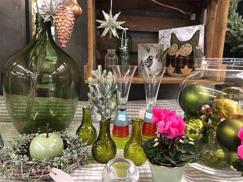 Ein Tisch mit Vasen voller Blumen und Weihnachtsdekorationen.