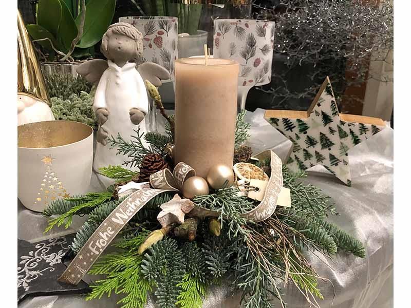 Eine Weihnachtsdekoration mit einer Kerze und einem Stern auf einem Tisch.