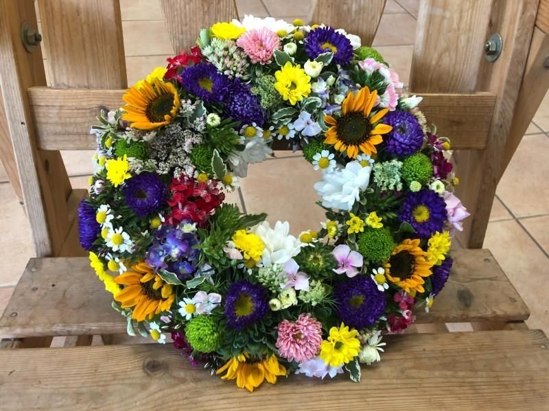 Ein Blumenkranz sitzt auf einem Holzstuhl