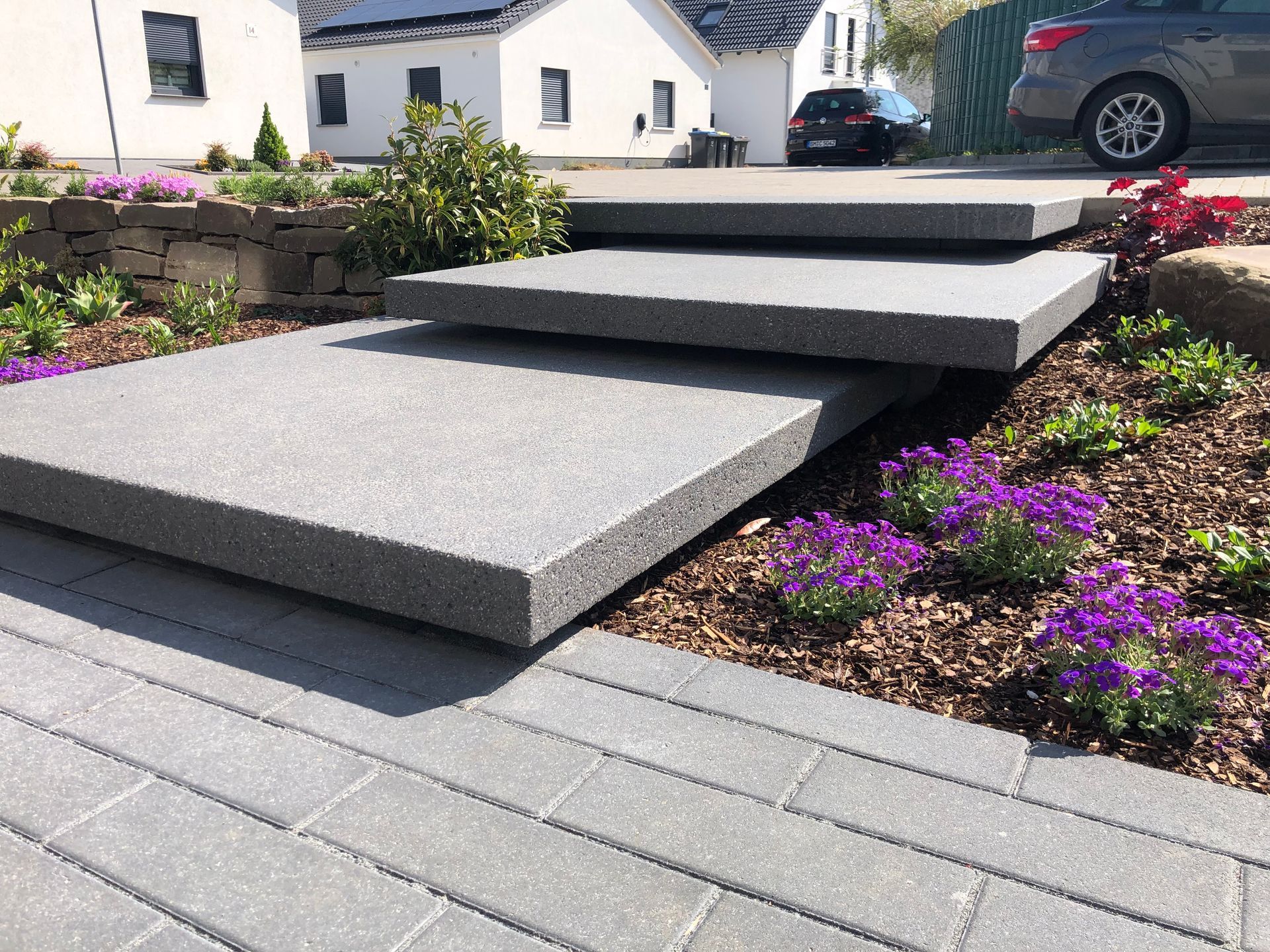 Eine Terrasse mit Tisch und Stühlen mit Blick auf einen üppigen grünen Garten