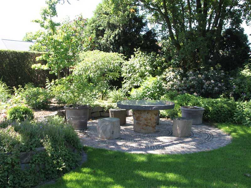 Ein Garten mit einem Tisch und Stühlen in der Mitte