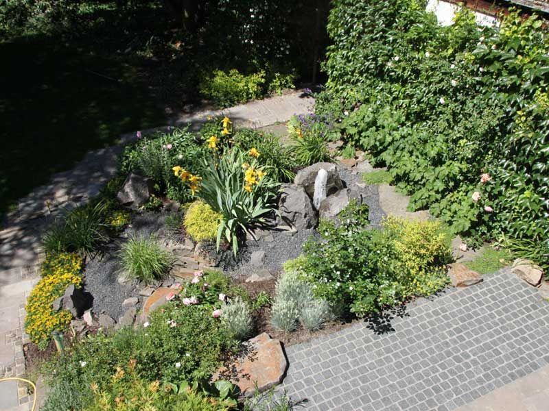 Eine Luftaufnahme eines Gartens voller Pflanzen und Steine.