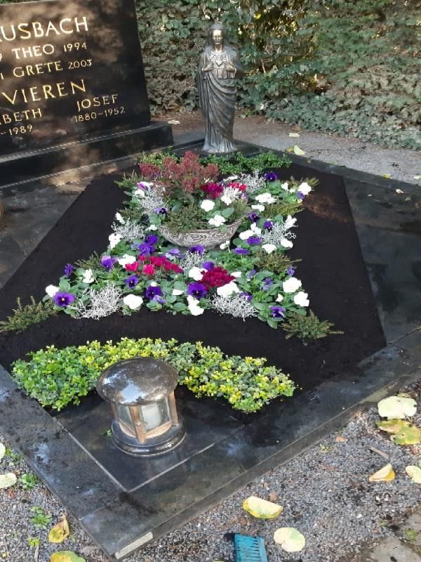 Ein Grab mit Blumen und einer Jesusstatue