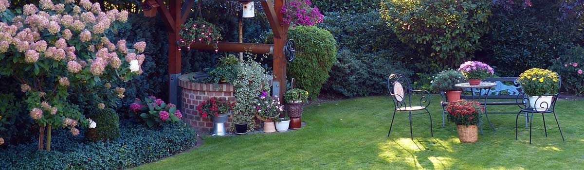 Ein Garten mit Tisch und Stühlen und Blumen