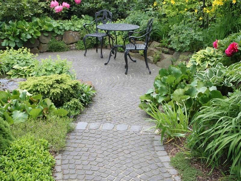 Eine Terrasse mit Tisch und Stühlen in einem Garten
